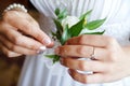 Bride puts groom on boutonniere from pink and whote rose on wedding day Royalty Free Stock Photo