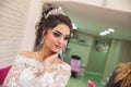 The bride puts her hand on her shoulder and takes a picture at the wedding. Wedding photo session in a beauty salon . The bride