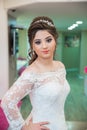 The bride puts her hand on her shoulder and takes a picture at the wedding. Wedding photo session in a beauty salon . The bride