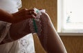 Bride puts on a wedding garter Royalty Free Stock Photo