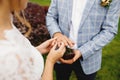 Bride puts wedding ring on groom finger. Boutonniere Royalty Free Stock Photo