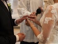 The bride puts the wedding ring on the groom`s finger during the ceremony in church under the supervision of the priest, Czech Rep Royalty Free Stock Photo