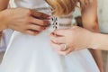 Bride putting on her white wedding dress. Wedding celebration concept. Beautiful lace wedding dress of the bride with Royalty Free Stock Photo