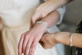 Bride putting on luxury bracelet on hand in the morning, getting ready.