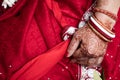 Bride in a red Sari. Beautiful traditional Indian wedding ceremony. bride`s hand is decorated with mehendi and bracelets. Hindu Royalty Free Stock Photo