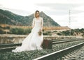 Bride with a red suitcase on the train tracks Royalty Free Stock Photo