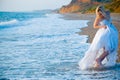 Bride running away from sea waves Royalty Free Stock Photo