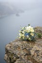 The brides bouquet lies on a wet stone, cloudy weather. mix of flowers white roses, blue hydrangeas, greens. rain droplets on the Royalty Free Stock Photo