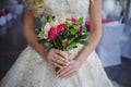 Bride`s bouquet. Beautiful girl in a luxurious wedding dress holding flowers Royalty Free Stock Photo