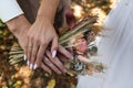 The bride`s bouquet of dried flowers in the hands of the newlyweds.