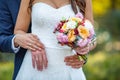 The bride`s bouquet. Wedding couple holding hands. Bride and groom hands with wedding rings and bridal dress Royalty Free Stock Photo