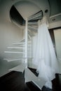 Bride`s dress on hanger on the stairs in the bride room. Wedding day