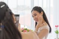 The bride`s friend is using a smartphone to take pictures of an Asian bride in a wedding dress that shows her left-hand diamond Royalty Free Stock Photo