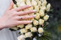 Bride`s hand with an elegant wedding ring with white gold diamonds on a bouquet of their peonies Royalty Free Stock Photo