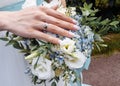 Bride`s hand with an elegant wedding ring with white gold diamonds on a bouquet of their peonies Royalty Free Stock Photo