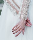 Bride`s hand with an elegant wedding ring with white gold diamonds on a bouquet of their peonies Royalty Free Stock Photo