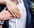 Bride`s hand with an elegant wedding ring with white gold diamonds on a bouquet of their peonies Royalty Free Stock Photo