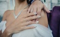 Bride`s hand with an elegant wedding ring with white gold diamonds on a bouquet of their peonies Royalty Free Stock Photo