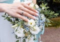 Bride`s hand with an elegant wedding ring with white gold diamonds on a bouquet of their peonies Royalty Free Stock Photo