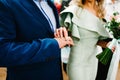 The bride`s hand wears an engagement gold ring on the groom`s finger. Wedding day. Hands with wedding rings. Close up Royalty Free Stock Photo