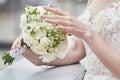 bride's hands adjust the white flowers in the bridal bouquet. close-up  blurred background  no face Royalty Free Stock Photo