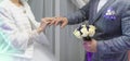 Bride`s hands place wedding ring on groom`s finger. Beautiful wedding ceremony.