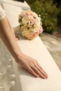 Bride's hands with wedding ring and bouquet of flowers Royalty Free Stock Photo