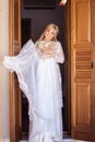 Bride`s morning - portrait of blonde young woman in white lingerie with her wedding dress Royalty Free Stock Photo
