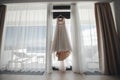 Bride`s morning. wedding dress at the window indoors Royalty Free Stock Photo