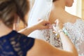 the bride's mother fastens the pearl buttons on the wedding dress. preparation for the ceremony the morning of the bride