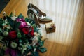 Bride`s shoes, wedding bouquet, two gold rings. Wedding accessories for the newlyweds, top view