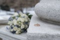 The bride\'s wedding bouquet lies on a stone slab