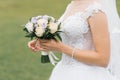 The bride`s wedding bouquet of milk roses and lilac eustoms in the hands of the bride close-up