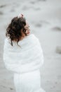 Bride on the seacoast. Fluttering hair and flowers in her hair looking away Royalty Free Stock Photo