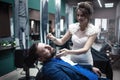 Bride shaves groom with a straight razor