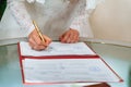 Bride signing signature on wedding certificate Royalty Free Stock Photo