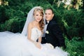 Bride sit together with groom on green grass park Royalty Free Stock Photo