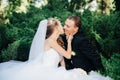 Bride sit together with groom on green grass park Royalty Free Stock Photo