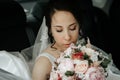 Bride sits at the car window on your wedding day with a bouquet Royalty Free Stock Photo