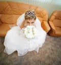 Bride sits on leathern sofa Royalty Free Stock Photo