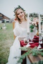 Bride sits near banquet table with candles and flower arrangement Royalty Free Stock Photo