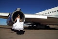 Bride sitting in engine of retired commercial airplane Royalty Free Stock Photo