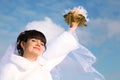 Bride smiles, raised her hand with bouquet