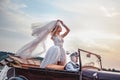 Bride standing in classic convertible while being driven Royalty Free Stock Photo