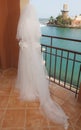 Bride stood on balcony in tropical coastal resort Royalty Free Stock Photo