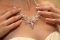 Bride straightens his jewelry on the neck