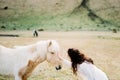 Bride strokes a white-red horse. Iceland