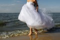 The bride runs on the surf line