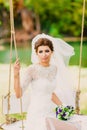 The bride on a swing on a background of the autumn landscape