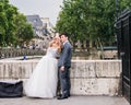 Bride takes a selfie of herself and her groom at the Pont de l'Archeveche, Paris